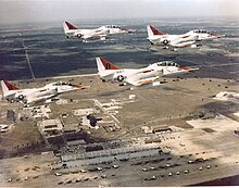 Four U.S. Navy Douglas TA-4J Skyhawks of Training Squadron VT-21 Redhawks in formation TA-4J Skyhawks VT-21 in flight over airfield c1980s.jpeg