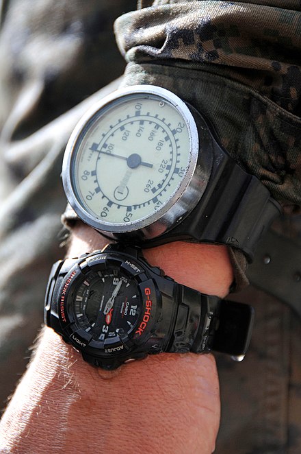 US Marine diver with a diving watch and an analog depth gauge
