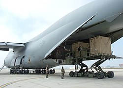 Members of Naval Mobile Construction Battalion Four (NMCB-4) load TriCon containers loaded with construction equipment destined for field testing in Iraq, into a U.S. Air Force, Air Mobility Command, C-5 Galaxy transport aircraft.