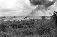 A Douglas A-1 Skyraider, A1E, drops napalm on a target spotted by an O-1 Bird Dog.