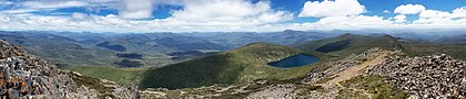 Vista a oeste da montanha Hartz no Parque nacional das Montanhas Hartz, no Vale Huon, Tasmânia, Austrália. É um dos 19 Parques Nacionais da Tasmânia e, em 1989, foi incluído na Área de Patrimônio Mundial da Natureza Selvagem da Tasmânia, em reconhecimento aos seus valores naturais e culturais. As montanhas Hartz receberam o nome da cordilheira Harz, na Alemanha. A maior parte do parque está a mais de 600 metros acima do nível do mar, com altitudes variando de 160 m a 1 255 m. A espinha dorsal da rocha no parque é dolerito, enquanto as áreas do sul em altitudes mais baixas são constituídas por rochas sedimentares formadas a partir de sedimentos depositados por fontes marinhas, glaciais e de água doce entre 355 e 180 milhões de anos atrás. (definição 10 046 × 2 156)