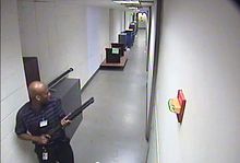 Freeze-frame shot of CCTV footage of the shooter in building 197 holding a Remington 870 shotgun.