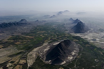 Mountains and plains just south-west of Kandahar city, which is beneath the haze on the right