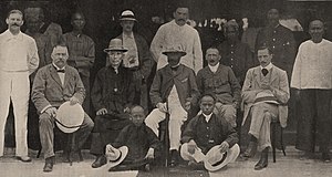 A large group of people, some sitting and others standing