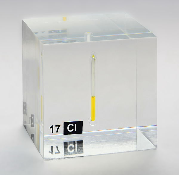 Chlorine, liquefied under a pressure of 7.4 bar at room temperature, displayed in a quartz ampule embedded in acrylic glass