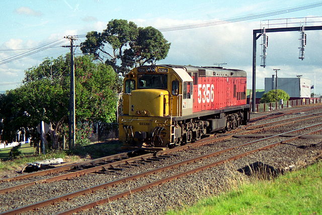 DX 5356 leaving Avondale in the late 1980s. The locomotive is painted in the International Orange or "Fruit Salad" livery of NZR from the late 1970s o