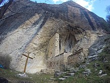 An small Hermitage located under a huge overhanging cliff