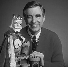 Fred Rogers ținând o marionetă de mână din cartierul Mister Rogers