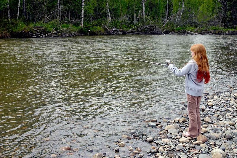 File:Girl stands on shore and fishes with her fishing rod.jpg