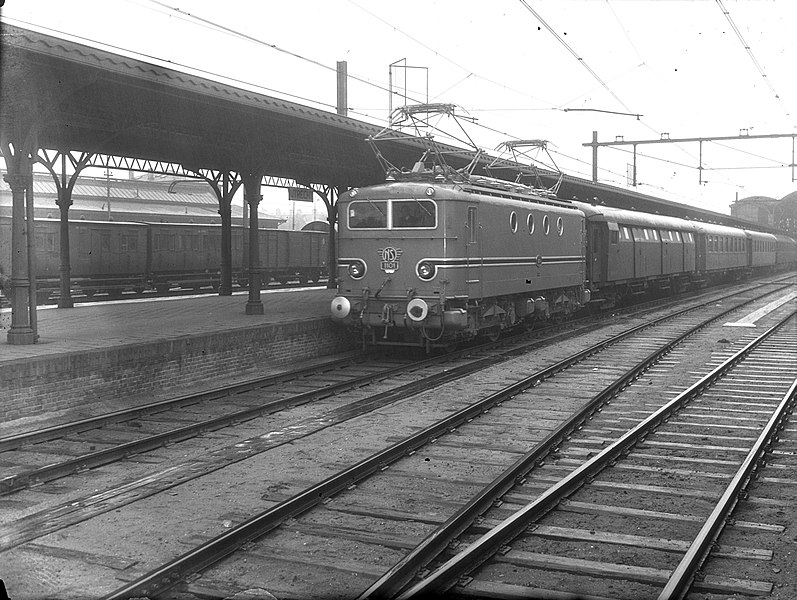 File:HUA-151103-Afbeelding van de electrische locomotief nr. 1101 (serie 1100) in turkooise beschildering met rijtuigen van de N.S. langs een perron van het N.S.-station Utrecht C.S. te Utrecht.jpg