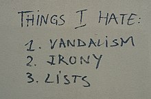 Граффити на стене с надписью «Вещи, которые я ненавижу: 1. Вандализм 2. Ирония 3. Списки»