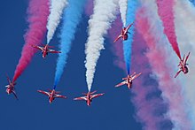 Red Arrows with red, white and blue smoke Red Arrows - RIAT 2014 (14650688158).jpg