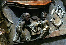 A Misericord in St Davids Cathedral depicting a merchant receiving a meal of a pig's head, served by a female servant. St.David's Cathedral - Miserikordien 6 Mahlzeit.jpg