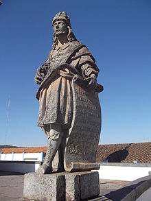 Photographie en couleurs. Statue en pied d'Osée, debout les pieds croisés et tenant un grand parchemin.