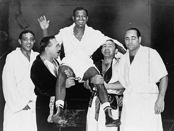 Sugar Ray Robinson being held aloft by Gene Fullmer and Carmen Basilio in 1965. Basilio engaged in five straight Fight of the Year contests from 1955 