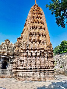 The temple, viewed from the south-east. The elaborate carvings on the exterior of the garbhagirha continue on the temple tower, which rises above it. 0102521 Siddhanath temple, Siddheshwar Mahadev temple, Nemawar, Madhya Pradesh 070.jpg