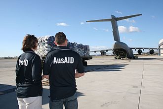 Two AusAID officers watching emergency relief supplies bound for Pakistan being loaded onto a Globemaster in August 2010 AusAID representatives supervising the loading of supplies in response to flooding in Pakistan. Amberley Queensland 2010. Photo- AusAID (10672825563).jpg