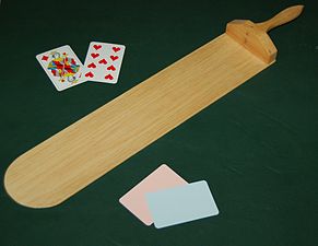 A baccarat palette and cards on a casino gambling table,