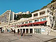 Le boulevard Prince de Galles sur la digue bordant la plage de la Côte des Basques à Biarritz. Au-dessus des douches pour baigneurs, se tient la terrasse du « bar de la Côte des Basque-Biarritz en bord de mer ». Ce bar-restaurant est la propriété des anciens rugbymans Marc Lièvremont et son frère Thomas.