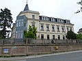 Tenement house with retaining wall and fence in a corner and open development