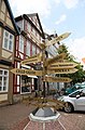Wegweiser-Kunstwerk mit den Siegeln, an Straßenecke namens „Markt“ neben historischem Alten Rathaus