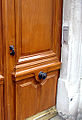 Een vaste deurknop onder in het midden van een Parijse deur met klopper.