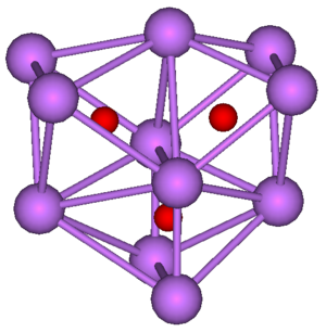 The ball-and-stick diagram shows three regular octahedra where each octahedron is connected to both of the others by one face each. All three octahedra have one edge in common. All eleven vertices of the structure are violet spheres representing caesium, and at the centre of each octahedron is a small red sphere representing oxygen.
