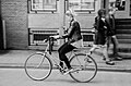 Woman riding bicycle while using music player (behavior: inventions, multitasking)