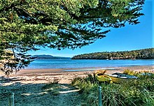 Egg og Bacon Bay strandsti til sandstrand med robåter til den ene siden