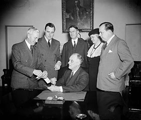 FDR buys a certificate enrolling him as "Founder No. 1" of the new National Foundation for Infantile Paralysis (1938)