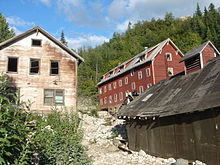 The Kennecott hospital (left) stood out as the town's only white-washed building. The vast majority of other town structures, including workers' bunkhouses (right), were painted red, the least expensive color at the time. The Kennecott hospital was also the site of the first X-ray machine in Alaska. Kennecott Hospital.jpg