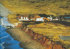 Geotextile sandbags protected the historic house Kliffende on Sylt island against storms, which eroded the cliffs left and right from the sandbag barrier. Kliffende, Island Sylt, 1999.jpg