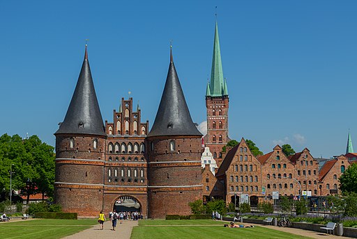 Lübeck: Blick über den Holstentorplatz ostwärts auf das Holstentor (Feldseite), rechts davon mehrere Salzspeicher, dahinter St. Petri
