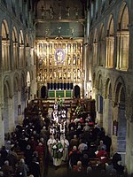 The nave at Wymondham Abbey, featuring Ninian Comper's Victorian reredos, is admired by the poet in the film. Nave procession.jpg