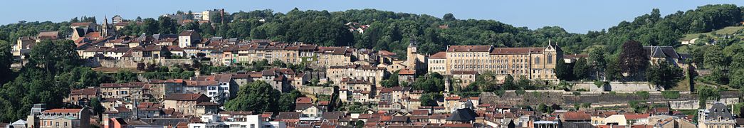 Panoramatický pohled na taškové střechy.  Staré domy na kopci v pozadí.