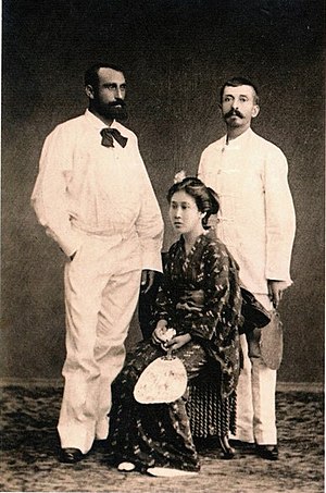 Two standing men in white and a sitting woman in kimono.
