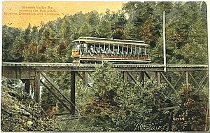 Streetcar on trestle surrounded by trees