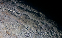 Patterns of blue-gray ridges and reddish material observed in the Tartarus Dorsa region on July 14, 2015 Snakeskin terrain on Pluto (PIA19957).png