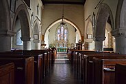 Het interieur van de Mariakerk, met de glas-in-loodramen en verschillende plaquettes aan de muren