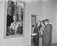 1955: koningin Juliana bekijkt samen met burgemeester Matser en directeur A.J. de Lorm het schilderij "Drie generaties" van Charley Toorop tijdens de tentoonstelling 'Vrouwen schilderen'.