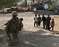 Local children watch United States Marines during the Iraq War