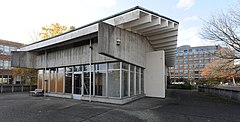 A concrete structure with an overhanging roof and large glass windows. The interior appears to be empty, with no equipment or lights.