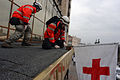 Ukrainian Red Cross society volunteers puting Red Cross flag above Ukraine hotel entrance to matrk it as a peaceful makeshift hospital. Clashes in Kyiv, Ukraine. February 20, 2014