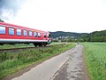 Zug der Kurhessenbahn zwischen Carlshütte und Buchenau in Richtung Marburg. Nebenan der Lahntalradweg