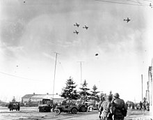 101st Airborne Division troops watch as C-47s drop supplies over Bastogne. Bastogne resupply1944 sm.jpg