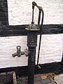 Water pump outside the 19th-century farm building.