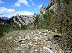 Abril: Runes de la masia dels Llengots, amb el Tossal del Bisbe al fons, enmig de la Serra dels Bastets, municipi de Guixers (Solsonès).