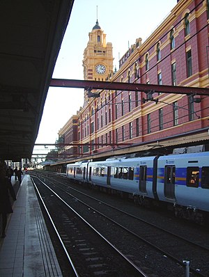 An X'Trapolis 100 on Platform 1 below the Elizabeth St clock tower