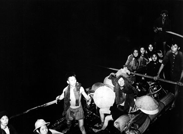 A photo published by the USIA allegedly showing Roman Catholic Vietnamese pulling alongside a French LST in 1954.