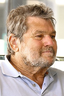 A three-quarters view of Wenner, seated and wearing a polo shirt
